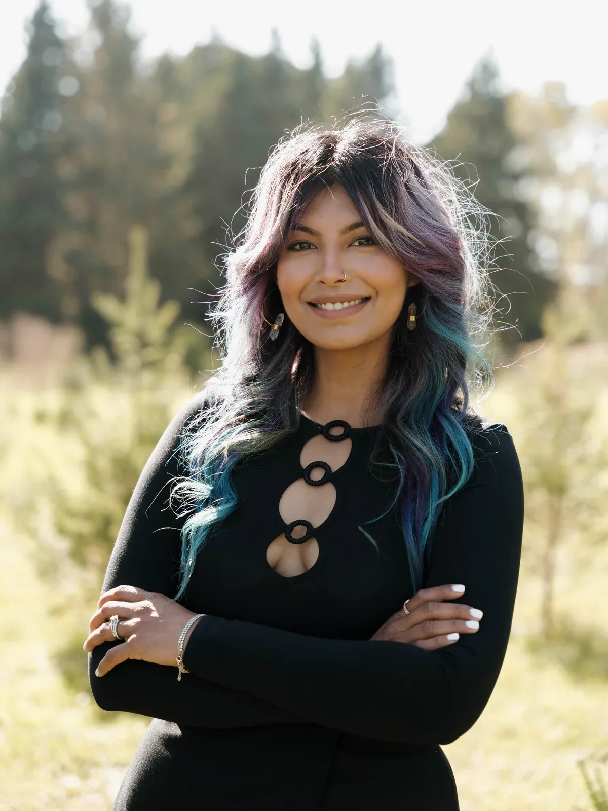 Portrait of Zineea outdoors, arms crossed, smiling
